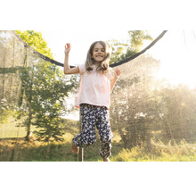 Ein Mädchen springt auf einem Gartentrampolin mit Sicherheitsnetz.