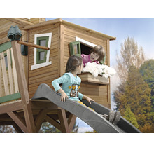 Kinderrutsche an einem Baumhaus mit zwei Kindern, eines auf der Rutsche und eines am Fenster