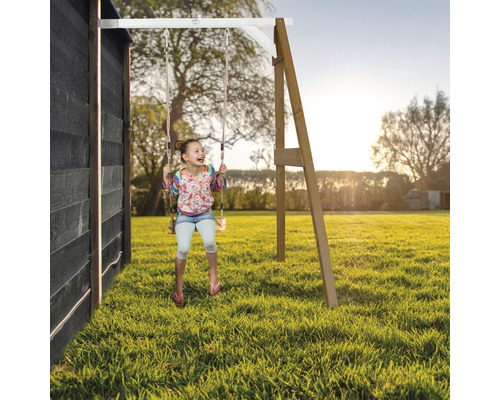 Mädchen schwingt auf einer Holzschaukel im Garten.
