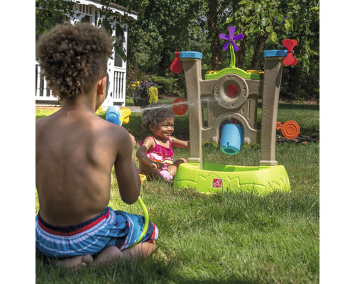 Kinder spielen mit einem Step2 Wasserspieltisch im Garten