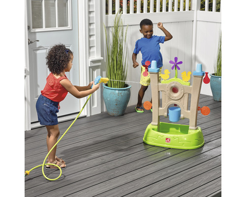 Zwei Kinder spielen mit einem Wasserspieltisch im Freien und benutzen eine Wasserspritzpistole.