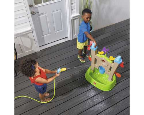 Zwei Kinder spielen mit einem Wasserspieltisch auf einer Terrasse.