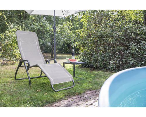 Szene im Garten mit Sonnenliege, Sonnenschirm, Tisch und Pool