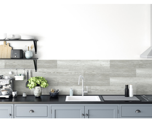 Küchenszene mit grauen Wandpaneelen in Holzoptik, Spüle, Armatur und Küchenutensilien.