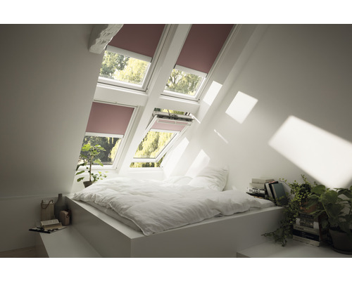 Helles Dachzimmer mit Bett und Dachfenstern mit Rollläden