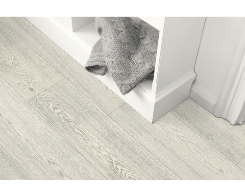 Heller Holzboden neben einem weißen Regal mit Strickdecke