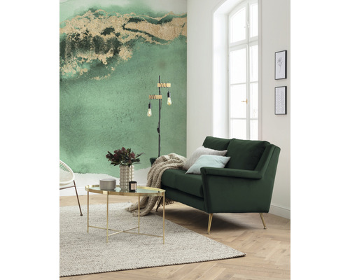 Helles Wohnzimmer mit grüner Couch, Couchtisch und gemusterter Tapete