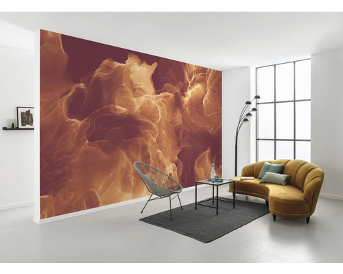 Heller Raum mit gemusterter Fototapete, Sessel, Teppich und Sofa.