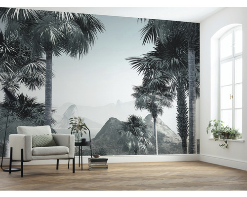 Wohnzimmer mit Fototapete mit Palmenmotiv und Sessel