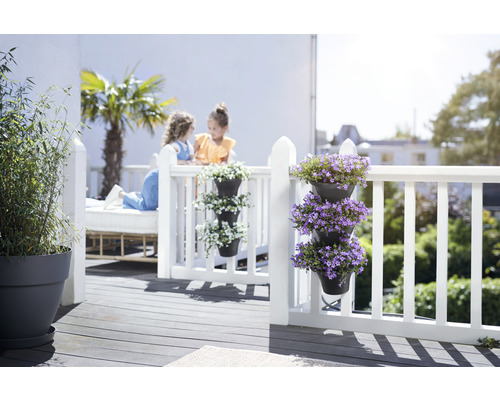 Balkonszene mit weißen Geländern, Blumenampeln und spielenden Kindern im Hintergrund