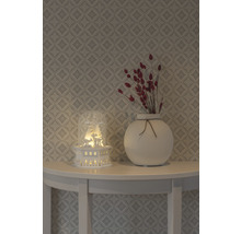 Dekoration mit Leuchthaus, Vase und Trockenblumen auf einem Tisch