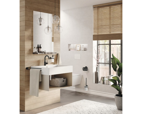 Badezimmer mit Waschtisch, Spiegel, hängender Toilette und Fenster mit Jalousie