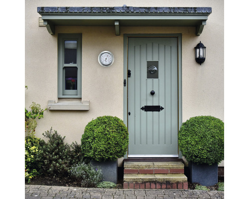 Eingangsbereich eines Hauses mit Haustür, Fenster, Außenlampe und Thermometer