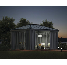 Pavillon mit Vorhängen, Tisch und Stühlen auf einer Terrasse bei Nacht