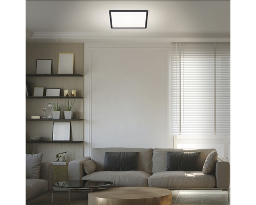 Modernes Wohnzimmer mit quadratischer Deckenleuchte und bequemer Couch