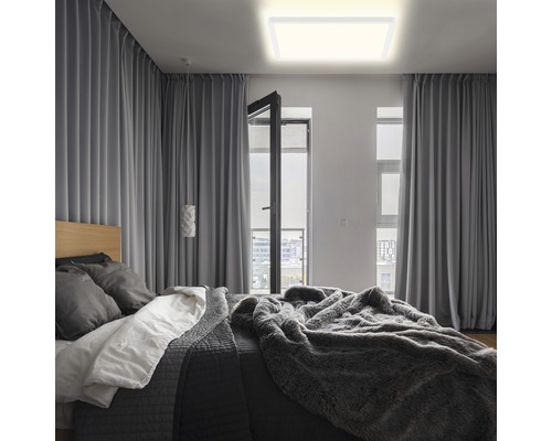 Schlafzimmer mit Bett, Vorhängen und quadratischer Deckenleuchte