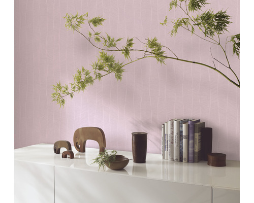 Wohnszene mit gemusterter Tapete, Bücher und Dekoration auf einem Sideboard