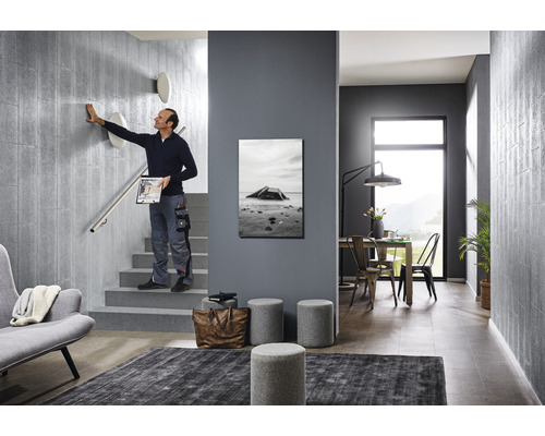 Szene eines modern gestalteten Treppenhauses mit einer Person, die eine Wand berührt, Möbeln und Dekorationen