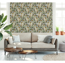 Ein Wohnzimmer mit einer Couch und einer Wandtapete mit Pflanzenmotiven.