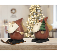 Zwei Räuchermännchen aus Holz auf Skiern mit Weihnachtsbaum und Sack im Hintergrund