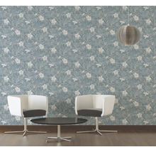 Ein Raum mit einer blauen Tapete mit Blumenmuster, zwei Stühlen und einem Tisch.