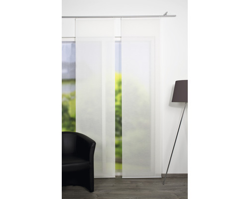 Zwei weiße Schiebegardinen mit einem Sessel und einer Lampe in einem Zimmer.