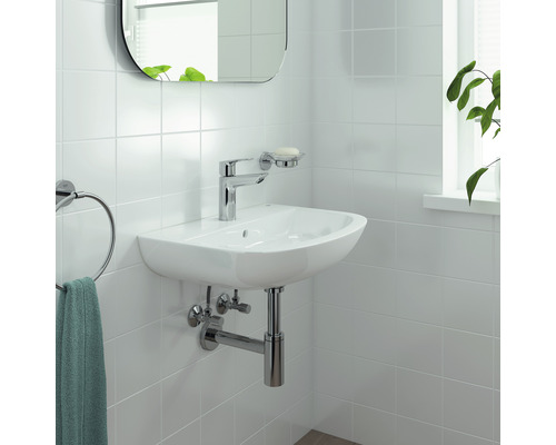 Waschbecken mit Armatur, Seifenschale, Spiegel und Handtuchhalter im Badezimmer