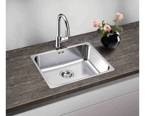 Spültisch mit Armatur und Abfluss auf einer Küchentheke mit Blumenvase