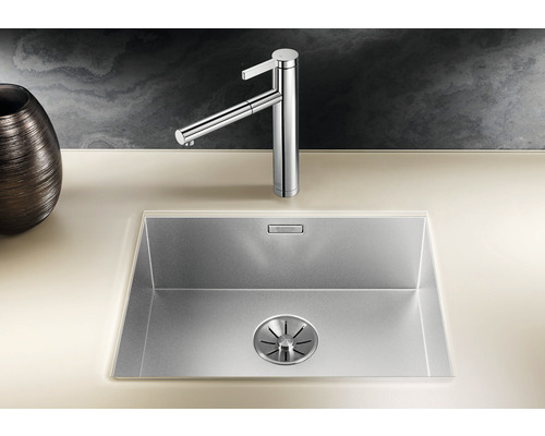 Spüle aus Edelstahl mit Wasserhahn auf einer Arbeitsplatte