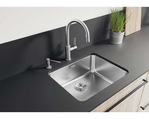 Edelstahlspüle mit Wasserhahn und Seifenspender auf einer Küchentheke