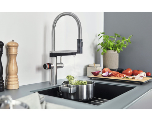 Küchenszene mit Spültischarmatur, Topf und Zutaten