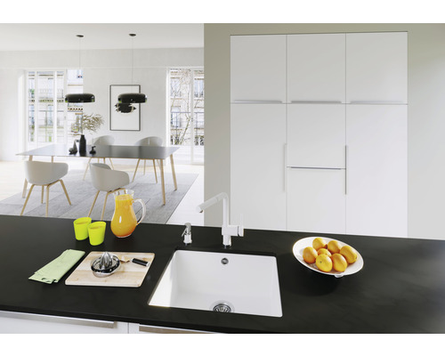 Helles Esszimmer mit Esstisch, Stühlen, Hängelampen und Küchenspüle auf einer Arbeitsplatte