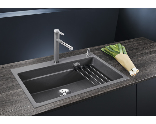 Spüle mit Armatur, Abtropfgitter und Lauch auf einer Küchentheke