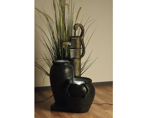 Dekorativer Zimmerbrunnen mit Pumpe, Wassergefäßen und Pflanzen