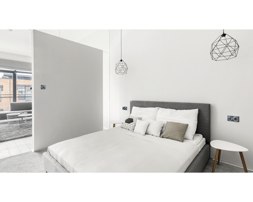 Helles Schlafzimmer mit Bett, Nachttischen und geometrischen Pendelleuchten