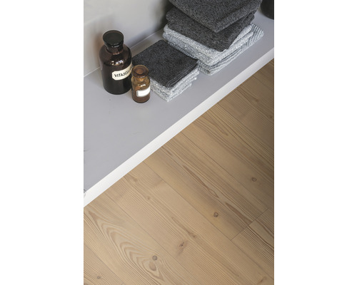 Regal mit grauen Handtüchern und Apothekerflaschen auf Holzboden