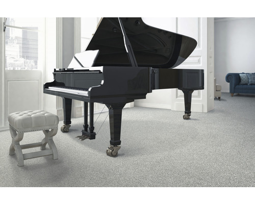 Szene mit einem Flügel, einem Hocker und einem Teppichboden in einem hellen Raum.