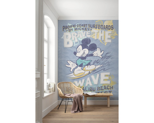 Zimmer mit einer Fototapete, die Mickey Maus beim Surfen auf einer Welle zeigt, mit dem Text Pacific Coast Surfboards.