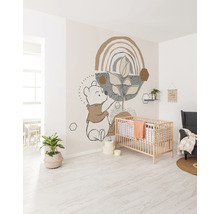 Helles Kinderzimmer mit Wandtattoo, Gitterbett und Sessel