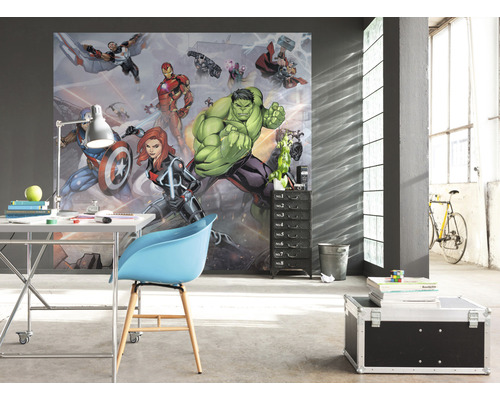 Ein Zimmer mit einer Fototapete mit Comicfiguren, einem Schreibtisch, einem Stuhl und einem Rollcontainer.