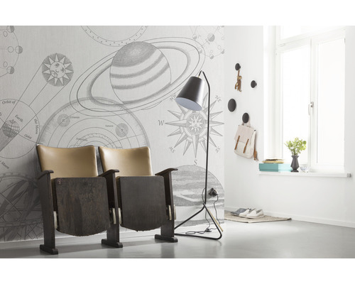 Raumansicht mit Tapete mit Planetenmuster, Theatersessel und Stehlampe