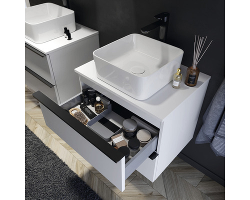 Badezimmer mit weißem Waschtisch, Aufsatzwaschbecken und Schublade mit Badutensilien