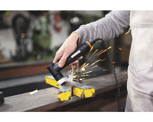 Eine Person schleift mit einer elektrischen Schleifmaschine ein Metallstück, wobei Funken sprühen.