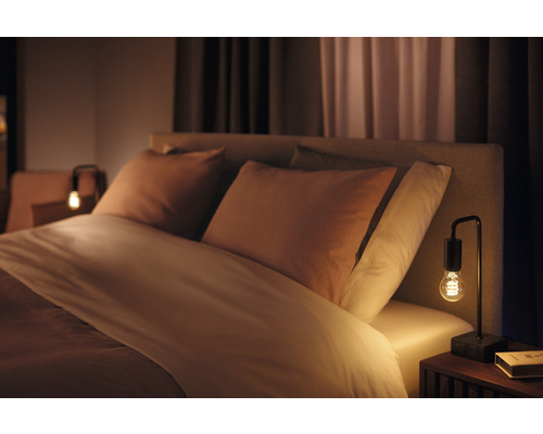 Schlafzimmer mit Bett, Kissen und Nachttischlampe