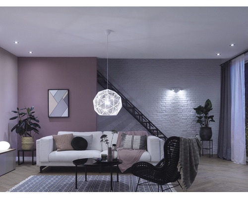Wohnzimmer mit Sofa, Sessel, Pendelleuchte und Deckenspots für eine helle Atmosphäre