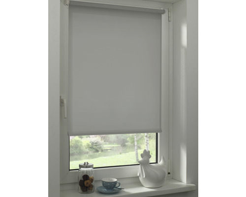 Blick auf ein Fenster mit einem grauen Rollo, das teilweise heruntergelassen ist