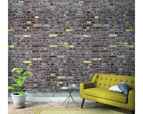 Wohnzimmer mit Backsteintapete, Sofa, Tisch und Pflanze.