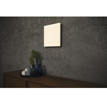 Quadratische Wandheizung über Holzkommode mit Dekoration an strukturierter Wand