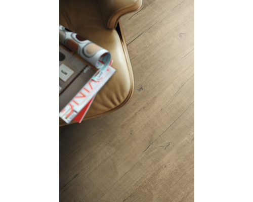 Nahaufnahme Laminatboden mit Holzstruktur neben Sessel und Zeitschrift