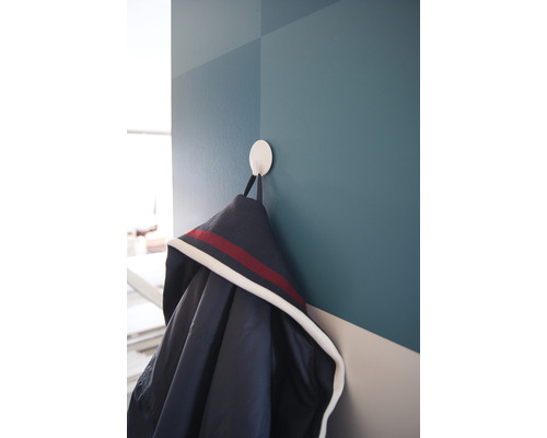 Jacke hängt an einem runden Wandhaken.